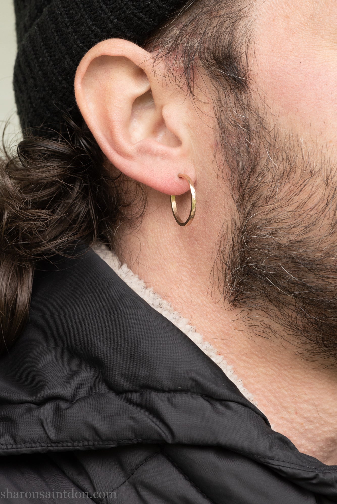 Hand hammered solid gold hoop earrings with a matte finish. 20mm diameter x 2mm wide x 1.5mm thick, worn on an ear.