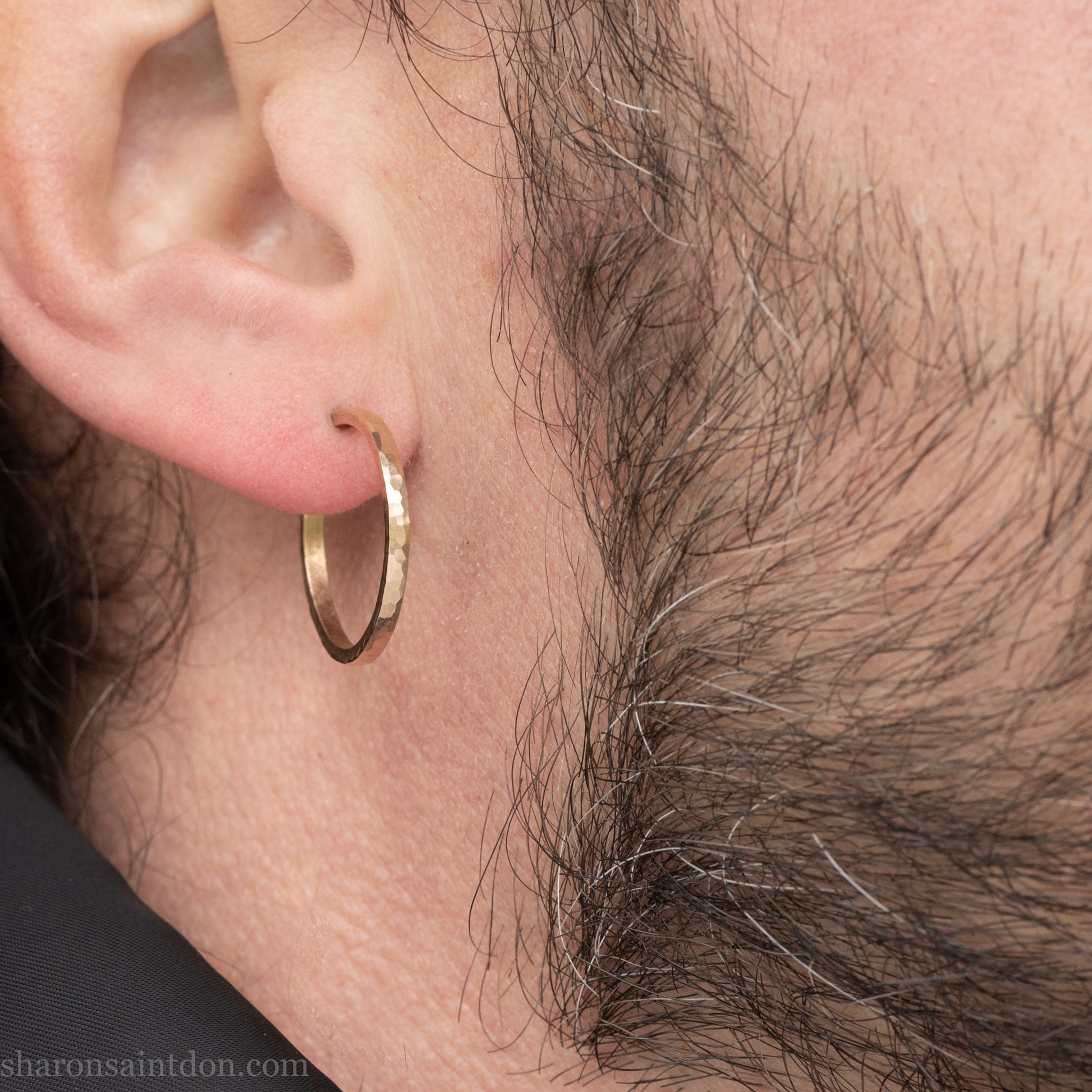 Hand hammered solid gold hoop earrings with a matte finish. 20mm diameter x 2mm wide x 1.5mm thick, worn on an ear.