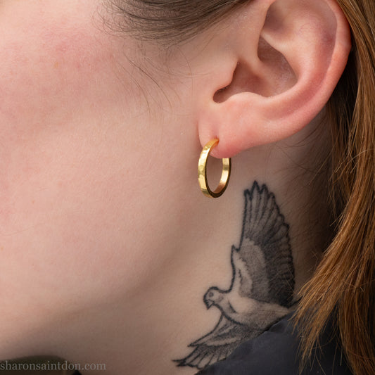 22k gold hoop earrings, 18mm diameter x 2mm . Hammered solid yellow gold with matte brushed finish. 18k gold posts and locking backs. Handmade by Sharon Saint Don in the USA.