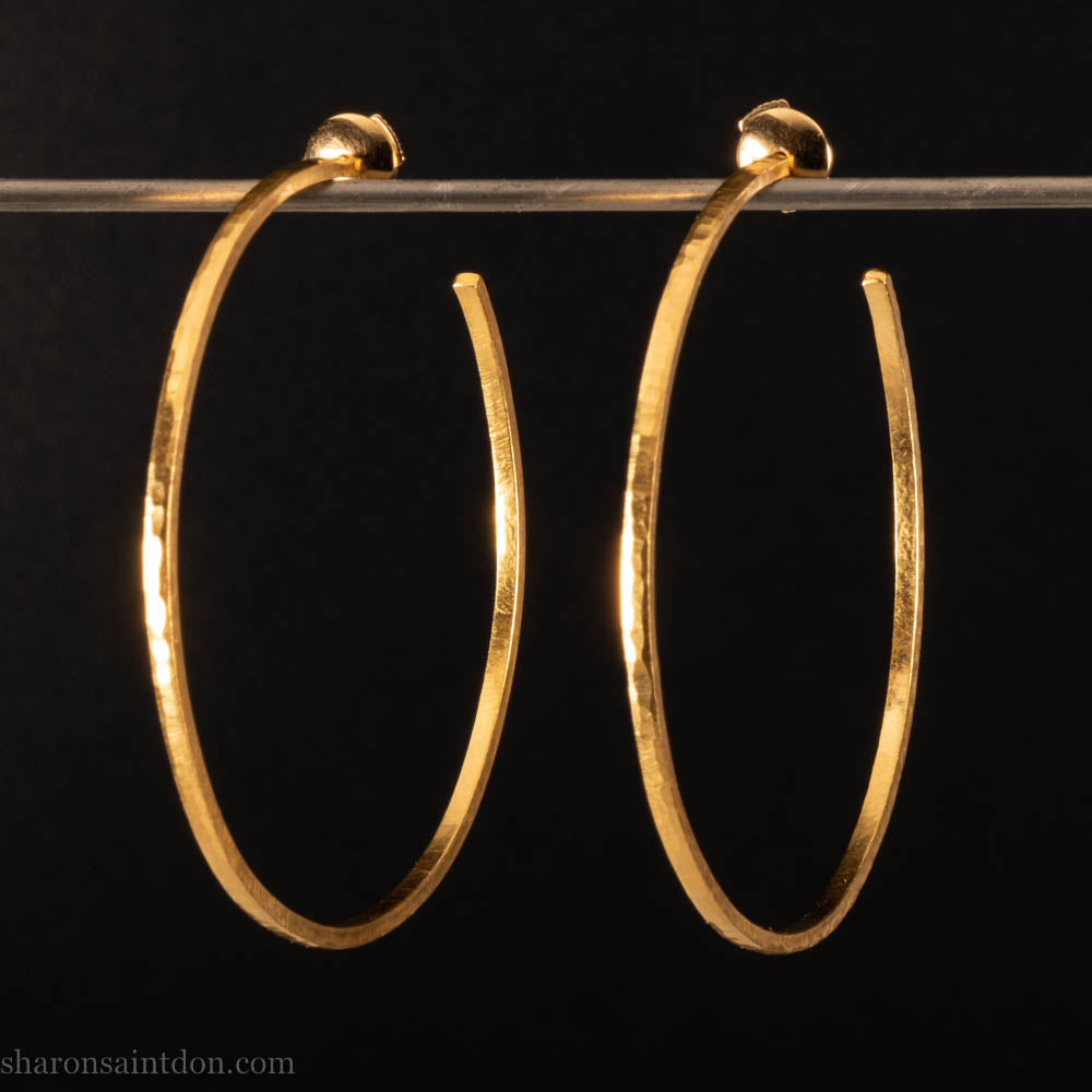 Solid 22k yellow gold hoop earrings for women. 55mm diameter, 1.5mm wide, 18k posts and locking backs. Handmade in the USA by Sharon Saint Don. Solid hammered yellow gold with sparkly, matte, brushed finish.