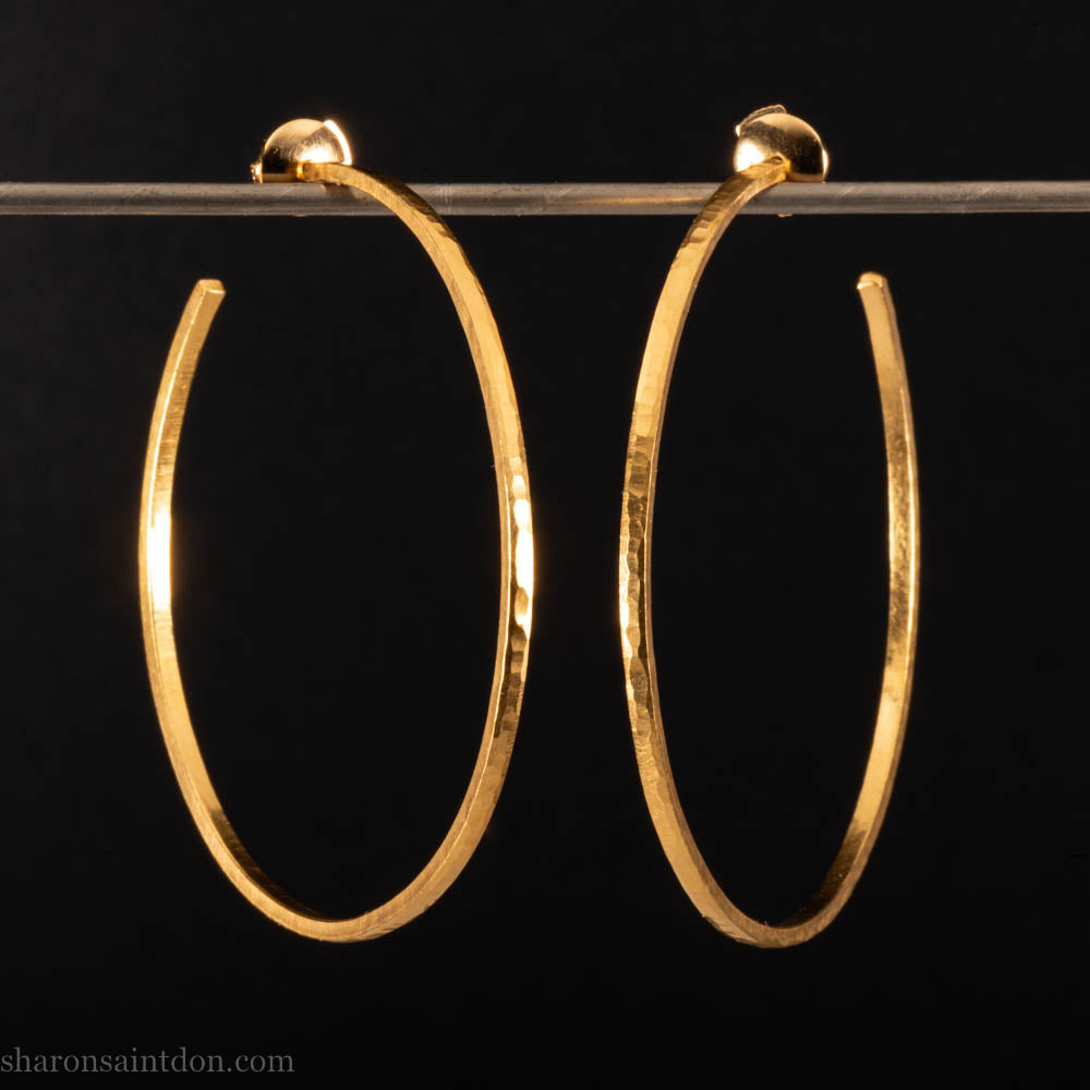 Solid 22k yellow gold hoop earrings for women. 55mm diameter, 1.5mm wide, 18k posts and locking backs. Handmade in the USA by Sharon Saint Don. Solid hammered yellow gold with sparkly, matte, brushed finish.