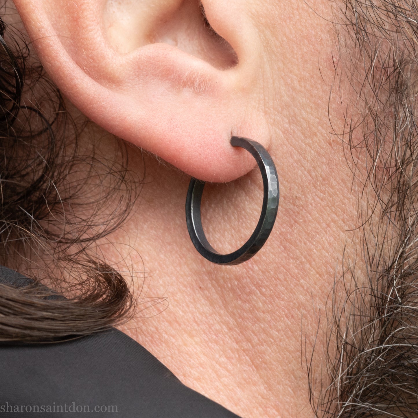 Hand hammered 925 sterling silver hoop earrings with an oxidized black finish. 20mm diameter x 2mm wide x 1.5mm thick, worn on an ear.