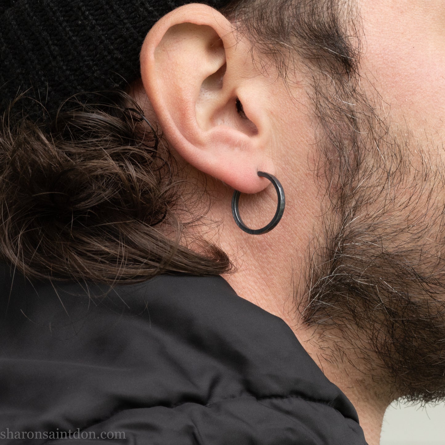 Hand hammered 925 sterling silver hoop earrings with an oxidized black finish. 20mm diameter x 2mm wide x 1.5mm thick, worn on an ear.