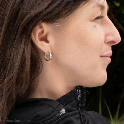 Hand hammered solid 925 sterling silver hoop earrings with a matte, brushed finish. 18mm diameter x 4mm wide x 1.5mm thick, worn on ear.