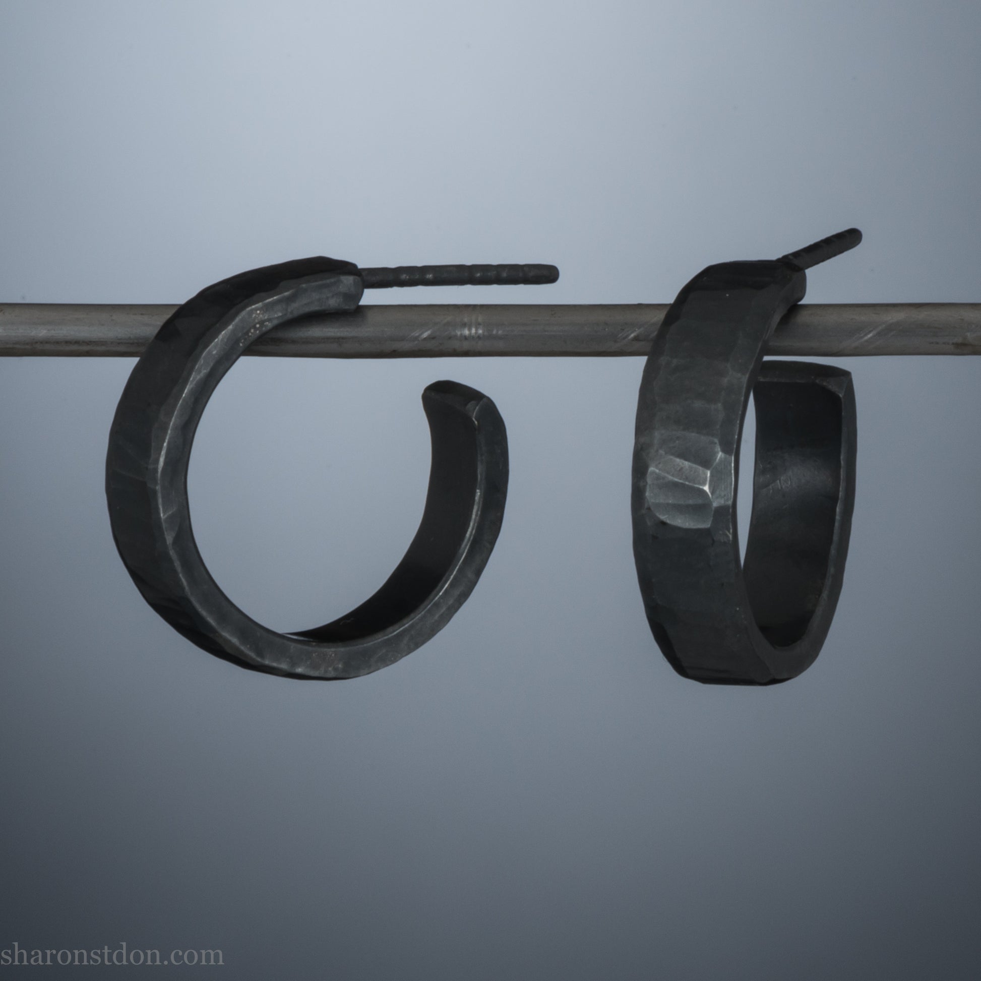 16 x 4mm x 1.5mm thick, 925 sterling silver hoop earrings. Handcrafted in the USA by Sharon Saint Don. Hammered solid silver with an oxidized black finish, silver posts and backs.