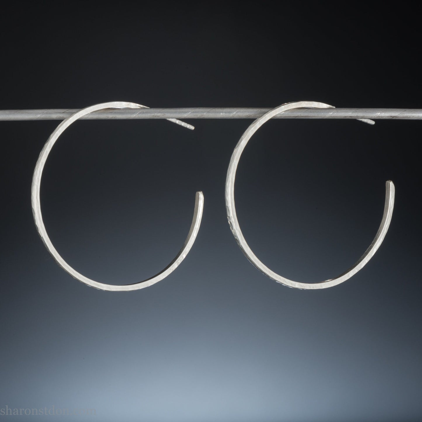 40mm diameter, 2mm wide, handmade 925 sterling silver hoop earrings. Comfortable, lightweight, daily wear hoop earrings with a hammered texture. Made by Sharon SaintDon in North America.