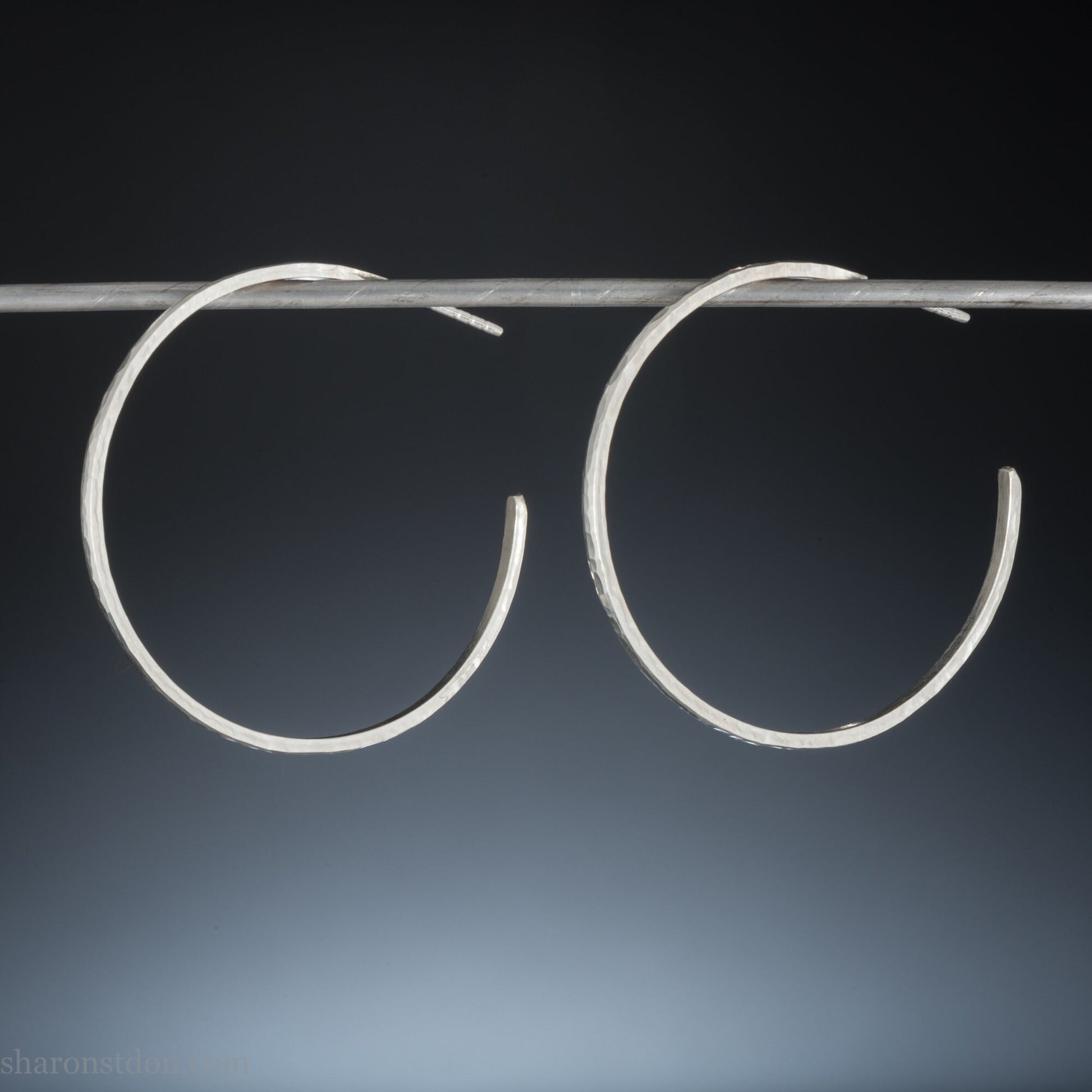 40mm diameter, 2mm wide, handmade 925 sterling silver hoop earrings. Comfortable, lightweight, daily wear hoop earrings with a hammered texture. Made by Sharon SaintDon in North America.