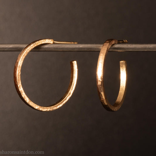 20mm diameter by 1.5mm thick  solid 14k yellow gold hoop earrings. Solid 14k gold posts and backs. Handmade by Sharon SaintDon in North America. Hammered from solid gold with a matte finish.