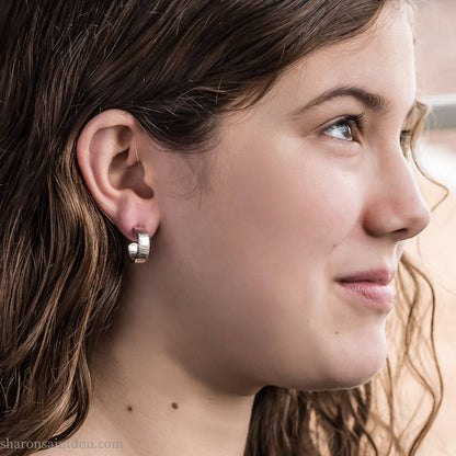 16 x 4mm x 1.5mm thick, 925 sterling silver hoop earrings handcrafted from solid, hand hammered real silver with a matte, brushed, shiny finish. Worn by teen girl with light skin and brown, wavy hair.