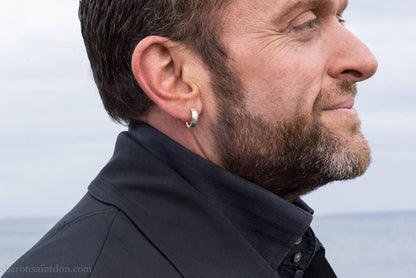 16 x 4mm x 1.5mm thick, 925 sterling silver hoop earrings handcrafted from solid, hand hammered real silver with a matte, brushed, shiny finish. Worn by a man with light skin, dark hair and beard.