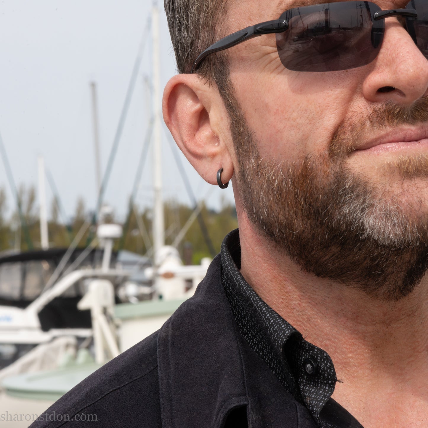 12mm black sterling silver hoop earrings for men on a man's ear, oxidized matte finish