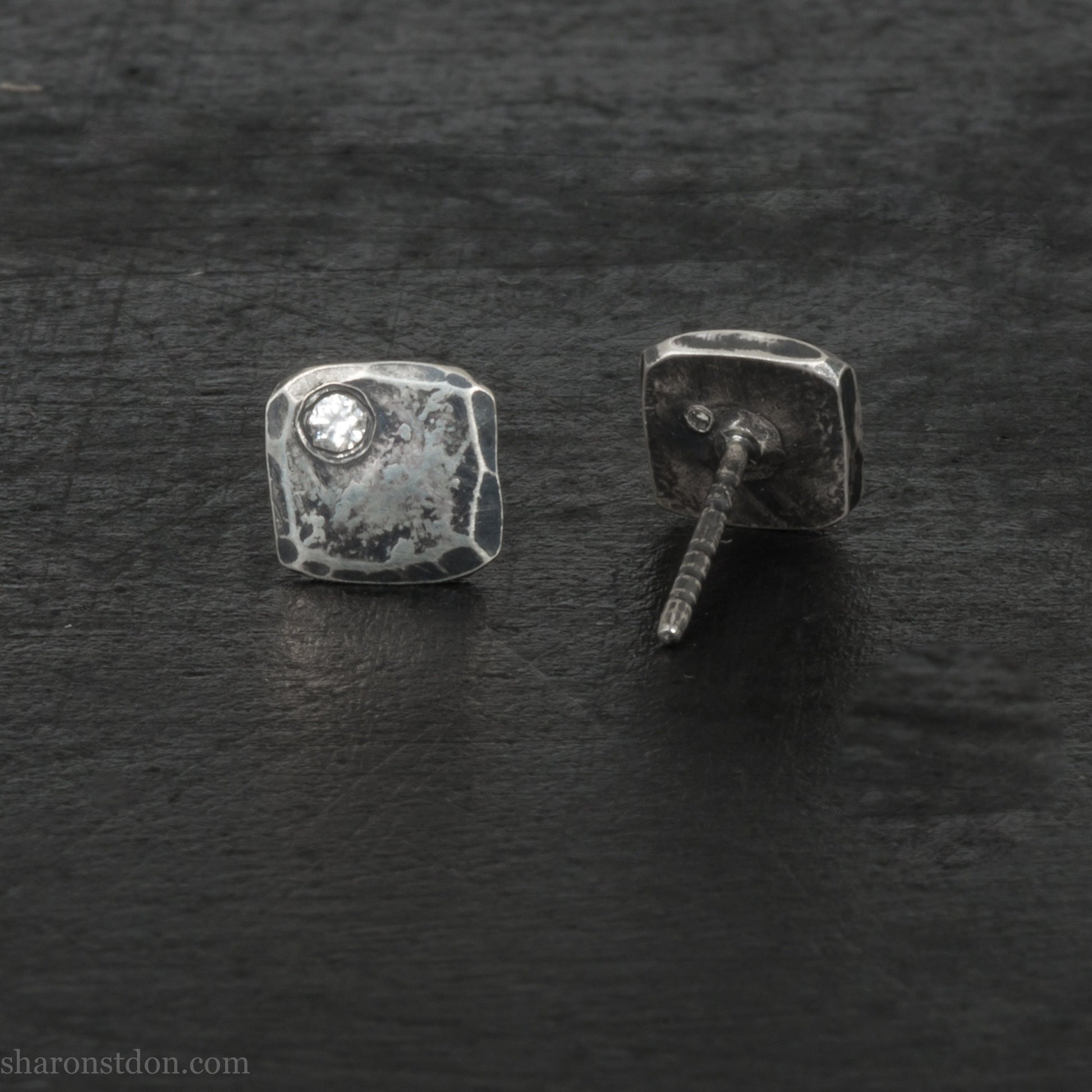 Small 925 sterling silver stud earrings for men with 2mm, imitation diamond gemstone set in the corner. 7mm square, 1.5mm thick with silver posts and backs and hammered, dark, antiqued finish. Handmade by Sharon SaintDon in North America.