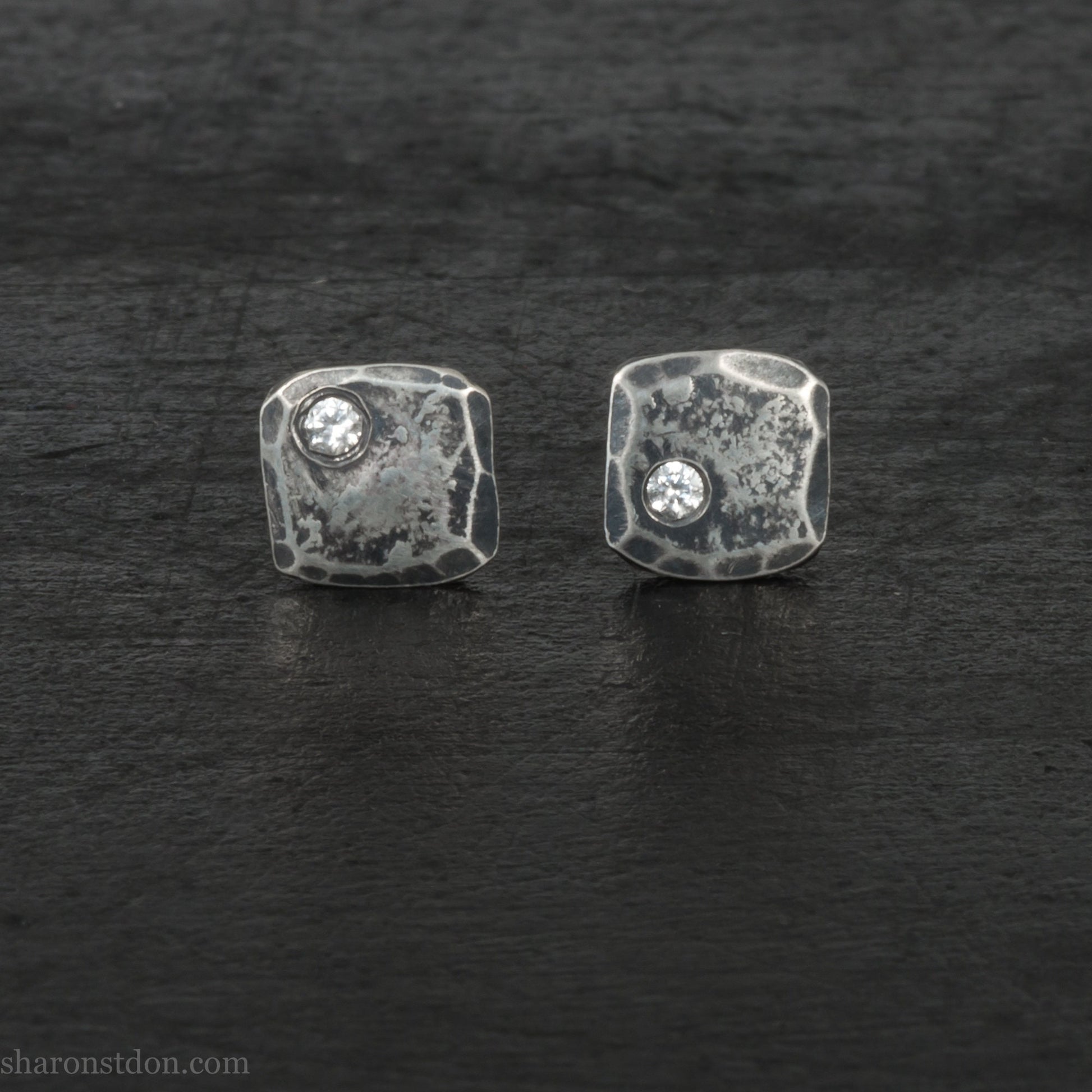 Small 925 sterling silver stud earrings for men with 2mm, imitation diamond gemstone set in the corner. 7mm square, 1.5mm thick with silver posts and backs and hammered, dark, antiqued finish. Handmade by Sharon SaintDon in North America.