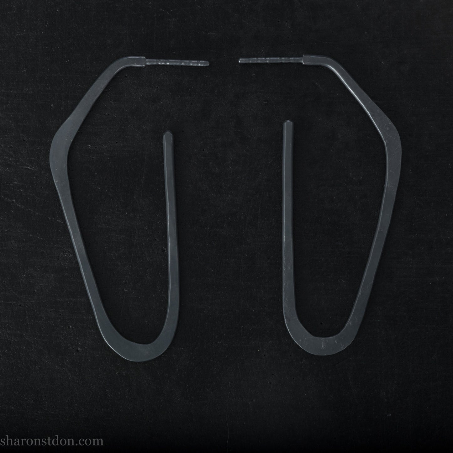 925 sterling silver hoop earrings handmade in North America by Sharon SaintDon. Long, angular, high D shape, oxidized black with hammered texture. SIZE: 47mm high x 19mm wide