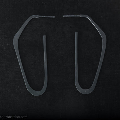 925 sterling silver hoop earrings handmade in North America by Sharon SaintDon. Long, angular, high D shape, oxidized black with hammered texture. SIZE: 47mm high x 19mm wide