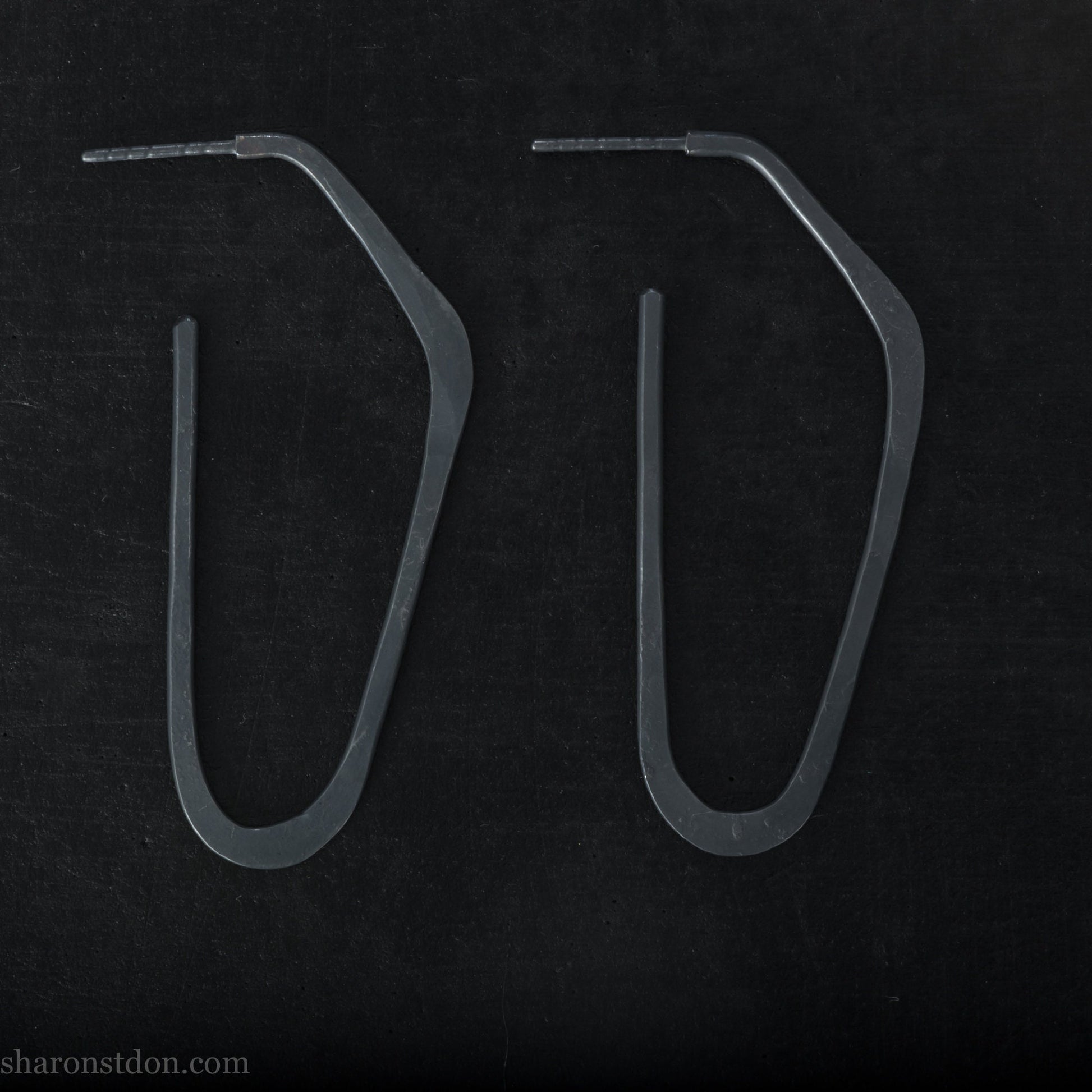 925 sterling silver hoop earrings handmade in North America by Sharon SaintDon. Long, angular, high D shape, oxidized black with hammered texture. SIZE: 47mm high x 19mm wide
