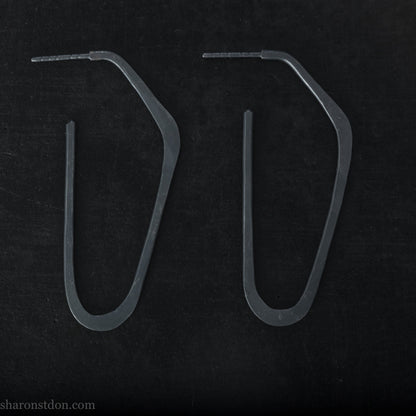 925 sterling silver hoop earrings handmade in North America by Sharon SaintDon. Long, angular, high D shape, oxidized black with hammered texture. SIZE: 47mm high x 19mm wide