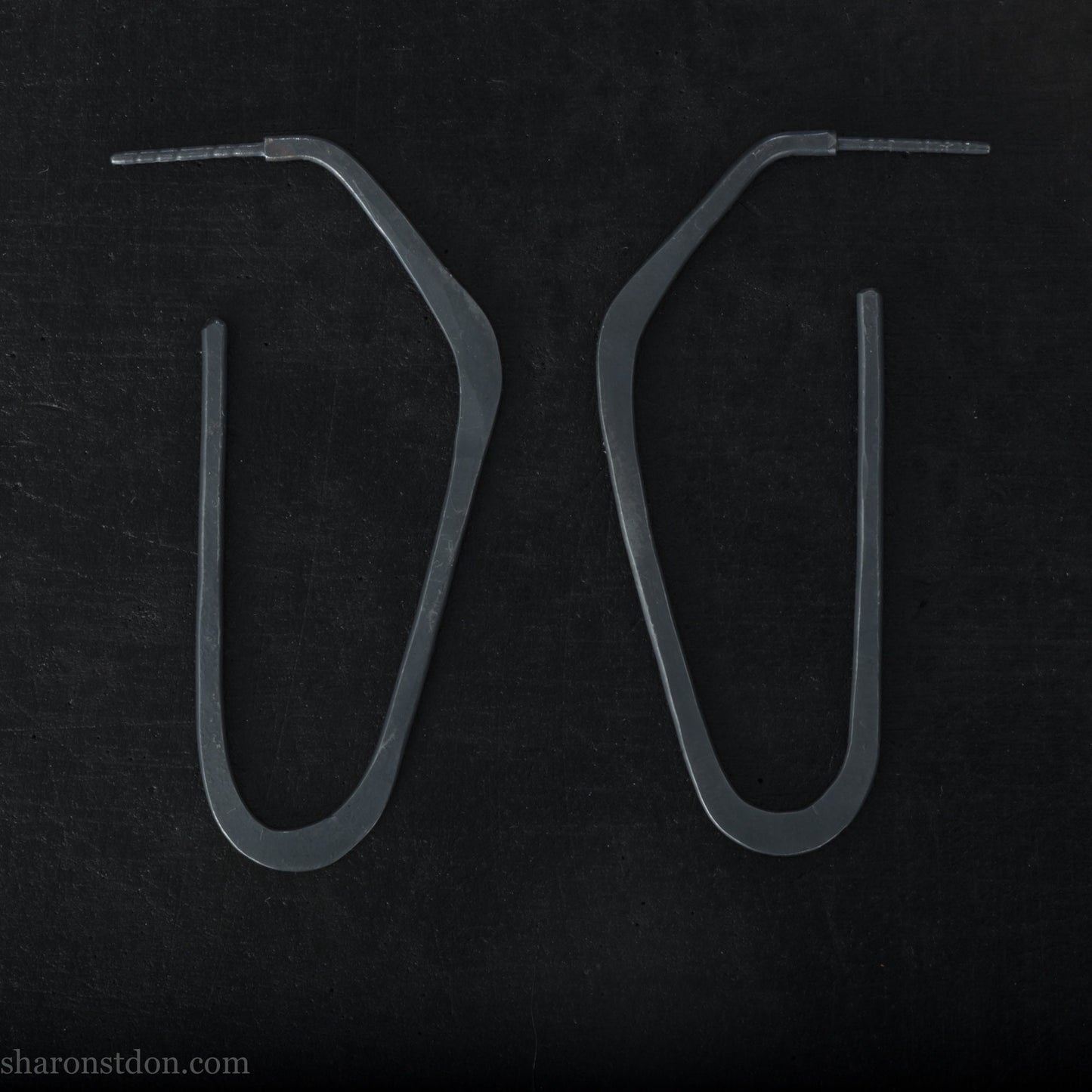 925 sterling silver hoop earrings handmade in North America by Sharon SaintDon. Long, angular, high D shape, oxidized black with hammered texture. SIZE: 47mm high x 19mm wide