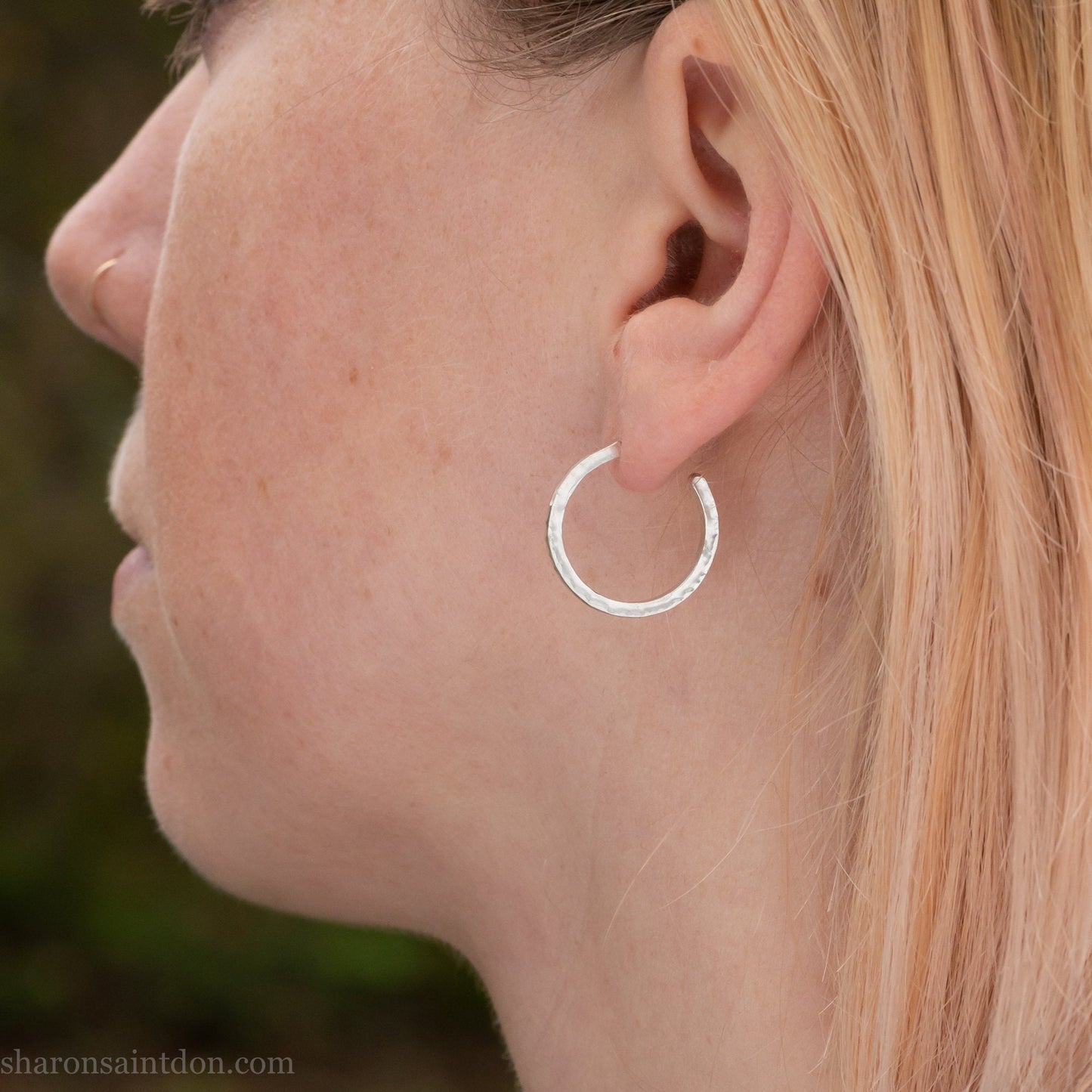 Hand hammered solid 925 sterling silver hoop earrings with a matte, brushed, finish. 20mm diameter x 2mm wide x 1.5mm thick, worn on an ear.