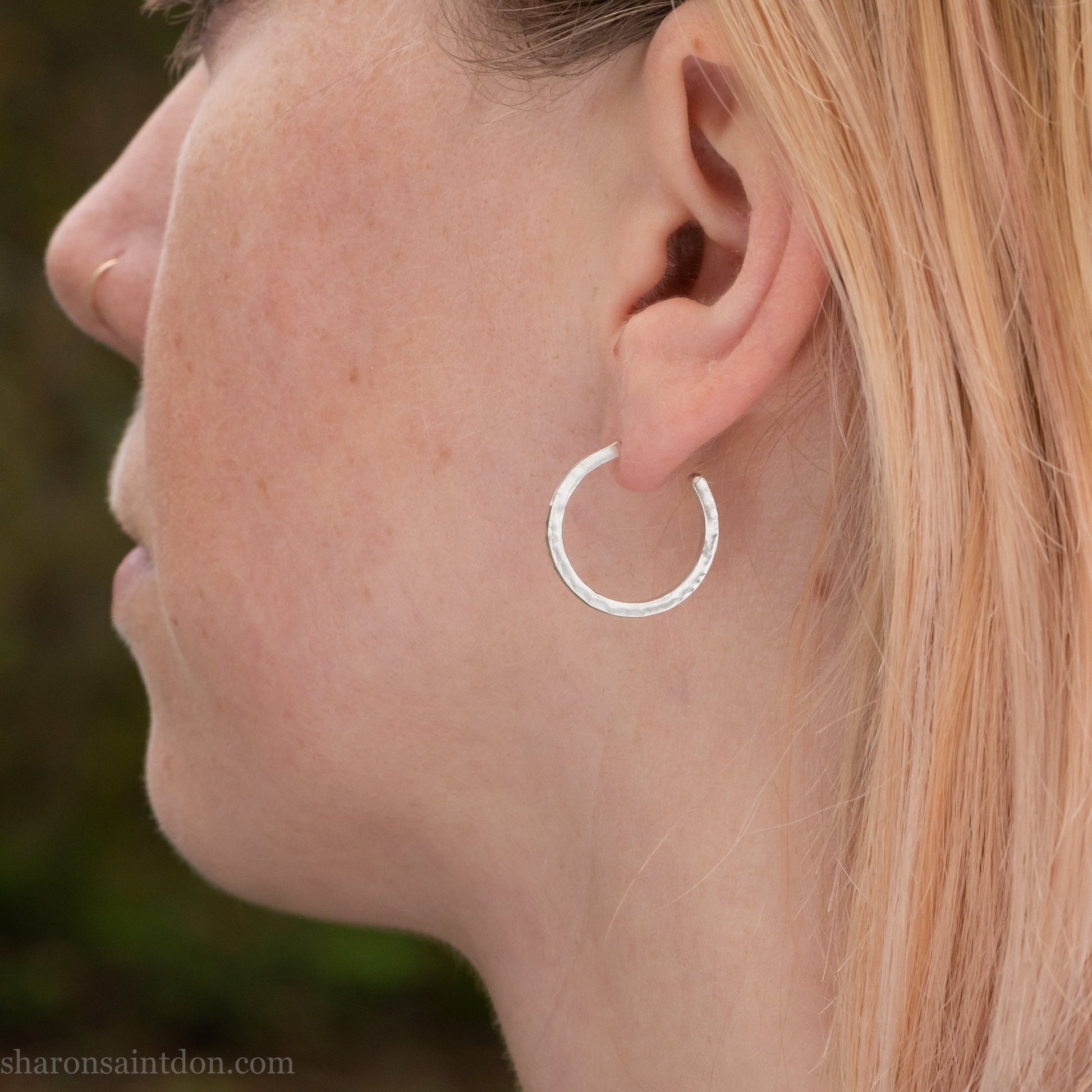 Hand hammered solid 925 sterling silver hoop earrings with a matte, brushed, finish. 20mm diameter x 2mm wide x 1.5mm thick, worn on an ear.