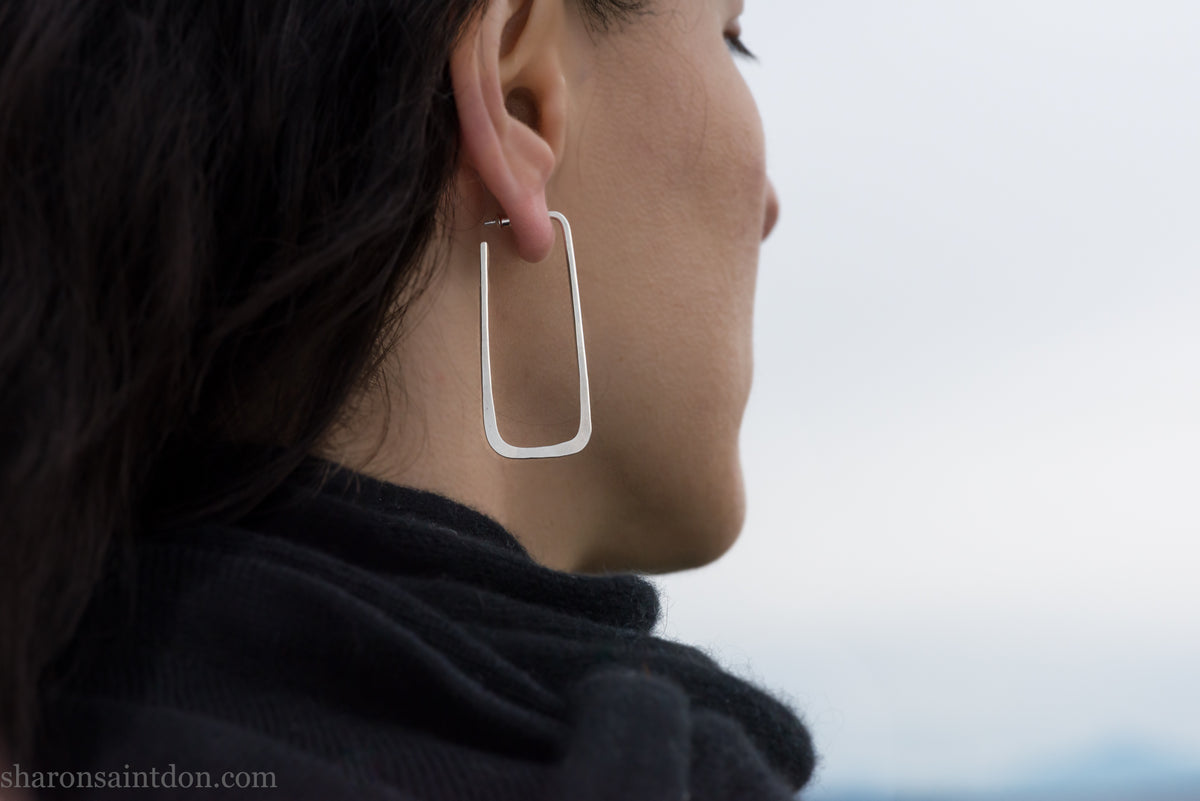 Long rectangle shape 925 sterling silver hoop earrings, worn on ear.