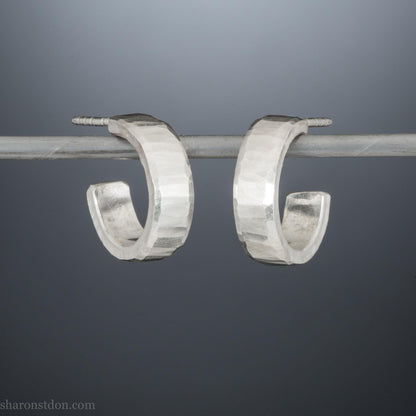 Close up photo of handcrafted 14mm x 4mm hammered solid sterling silver hoop earrings.