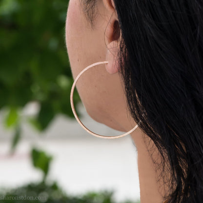 Solid 22k yellow gold hoop earrings for women. 55mm diameter, 1.5mm wide, 18k posts and locking backs. Handmade in the USA by Sharon Saint Don. Solid hammered yellow gold with sparkly, matte, brushed finish.