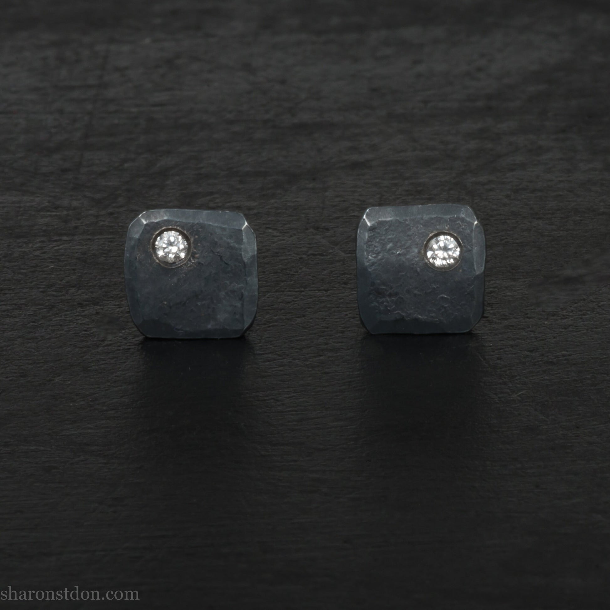 Solid 925 sterling silver stud earrings with 2mm round cubic zirconia lab grown gemstone set in the corner. 7mm square, 1.5mm thick, hammered silver with black oxidized tarnished finish. Handmade by Sharon SaintDon in the USA.