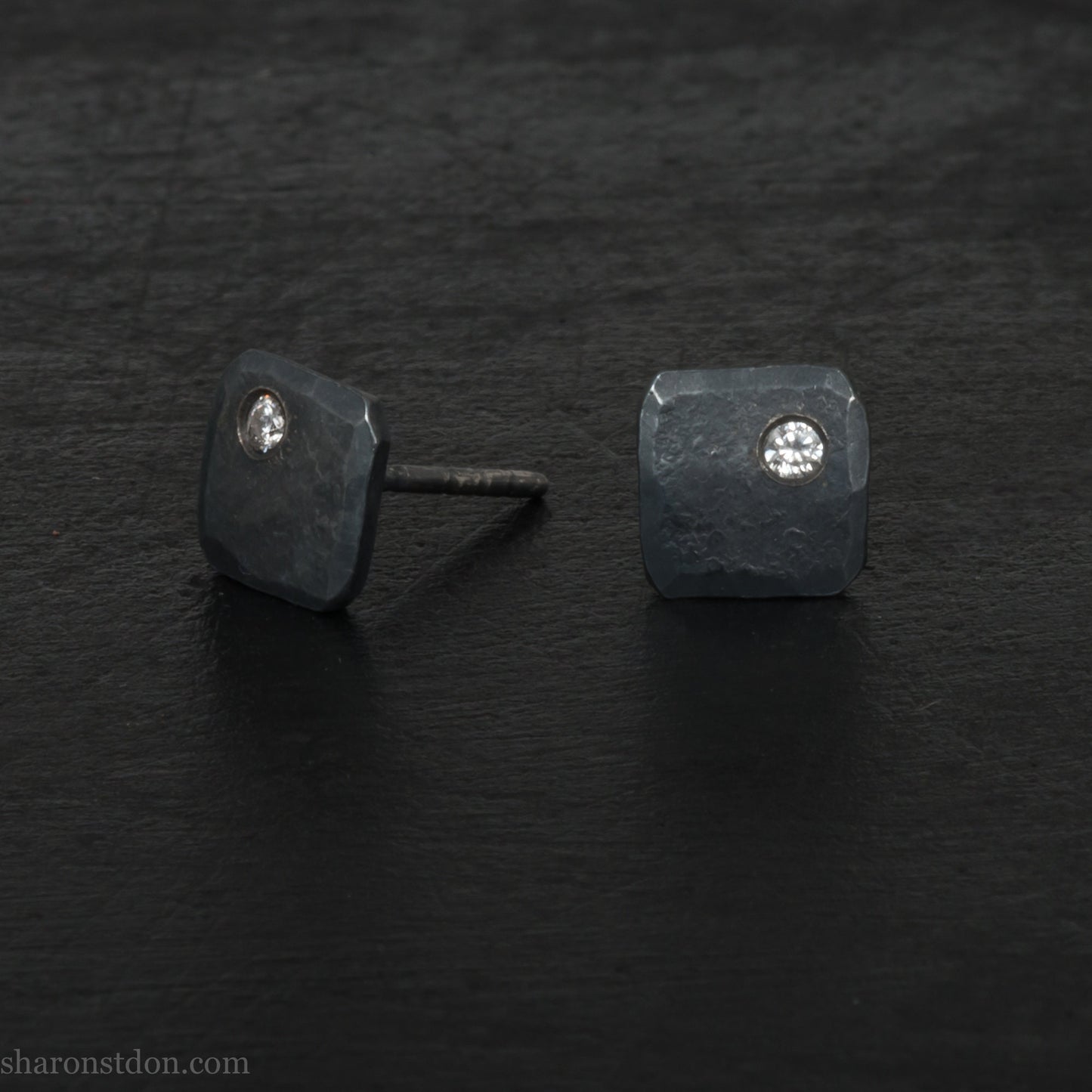 Solid 925 sterling silver stud earrings with 2mm round cubic zirconia lab grown gemstone set in the corner. 7mm square, 1.5mm thick, hammered silver with black oxidized tarnished finish. Handmade by Sharon SaintDon in the USA.