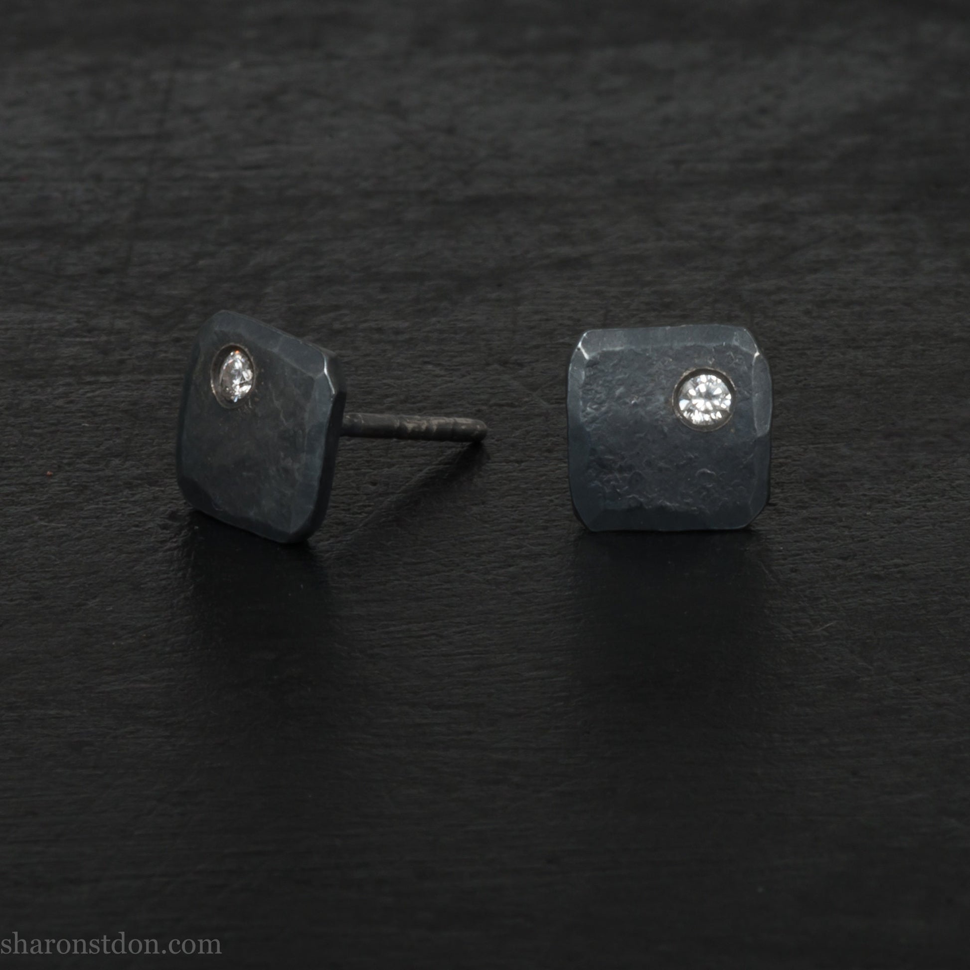 Solid 925 sterling silver stud earrings with 2mm round cubic zirconia lab grown gemstone set in the corner. 7mm square, 1.5mm thick, hammered silver with black oxidized tarnished finish. Handmade by Sharon SaintDon in the USA.