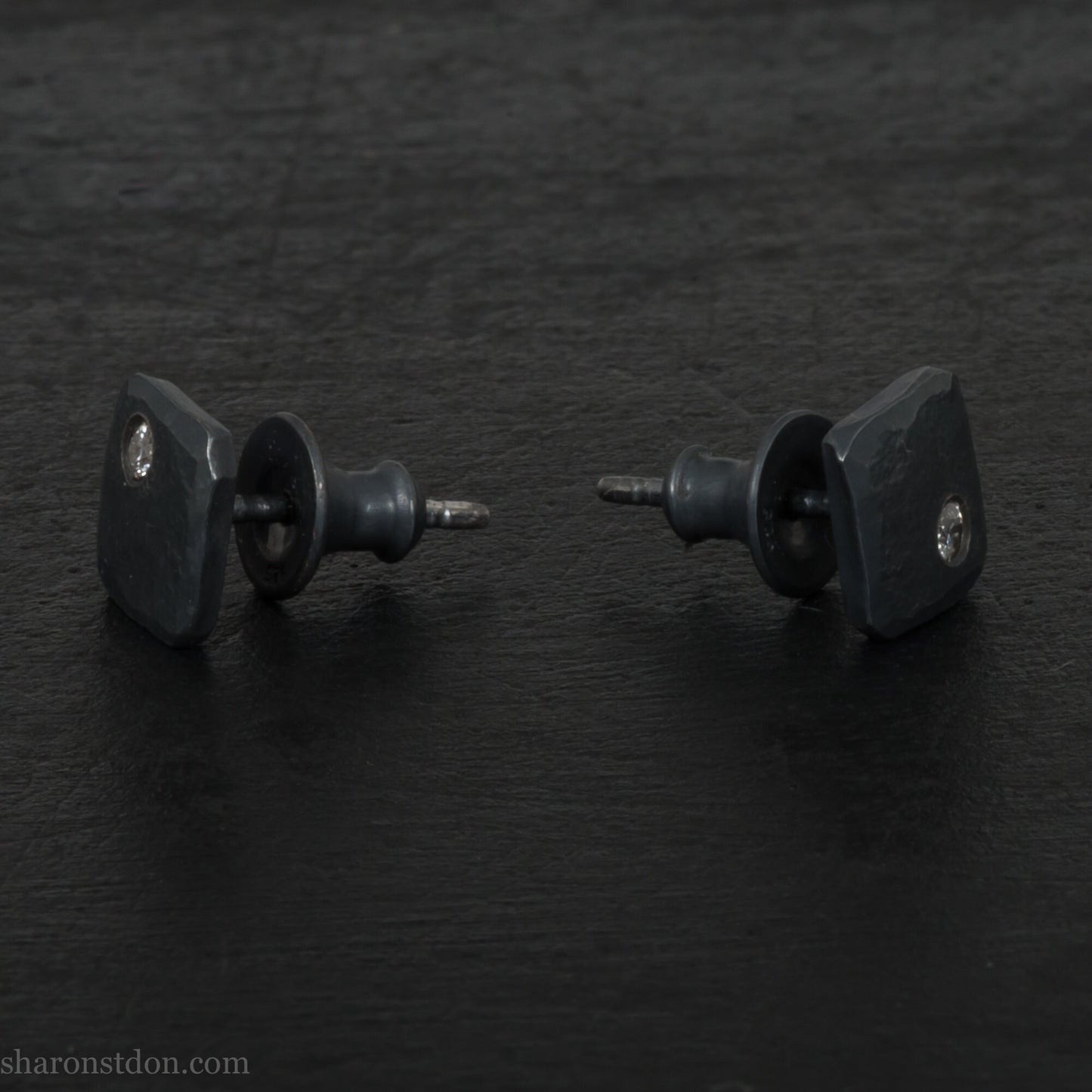 Solid 925 sterling silver stud earrings with 2mm round cubic zirconia lab grown gemstone set in the corner. 7mm square, 1.5mm thick, hammered silver with black oxidized tarnished finish. Handmade by Sharon SaintDon in the USA.