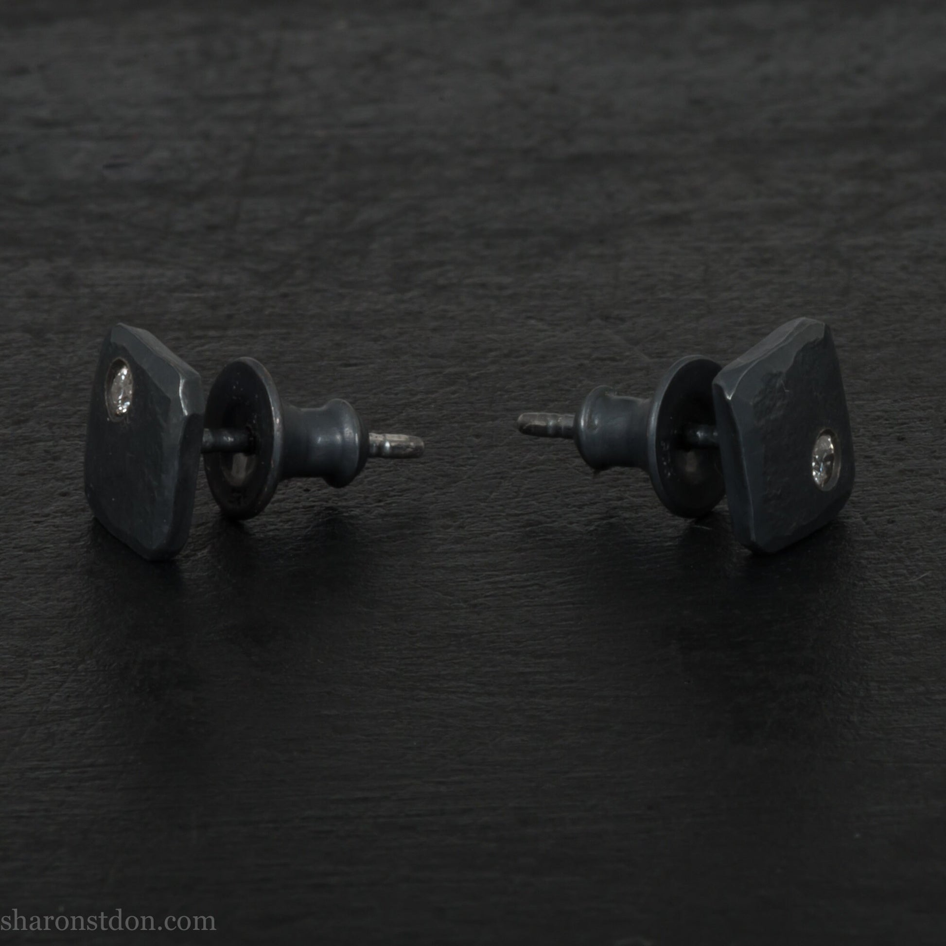 Solid 925 sterling silver stud earrings with 2mm round cubic zirconia lab grown gemstone set in the corner. 7mm square, 1.5mm thick, hammered silver with black oxidized tarnished finish. Handmade by Sharon SaintDon in the USA.