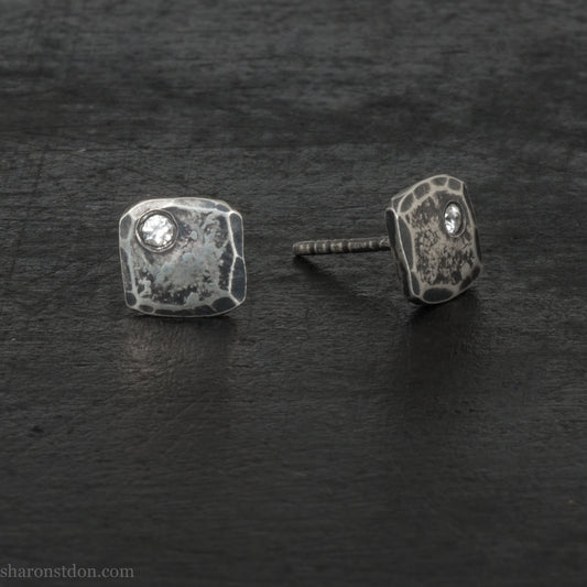 Handmade 925 sterling silver stud earrings with 2mm round moissanite lab grown gemstone set in the corner. 7mm square, 1.5mm thick, solid hammered silver with antiqued, dark finish. Posts and backs are sterling silver.