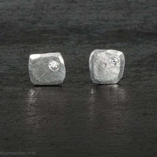 Handmade 925 sterling silver stud earrings with moissanite lab grown alternative diamond gemstones. 7mm square, 1.5mm thick, solid hammered silver with shiny, matte, brushed finish. Stone is set in the corner, posts and backs are sterling silver.