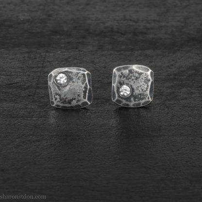 Hammered 925 sterling silver stud earrings with 2mm round lab grown cubic zirconia gemstone set in the corner. 7mm square, 1.5mm thick, dark antique finish, silver posts and backs. Handmade by Sharon SaintDon in North America