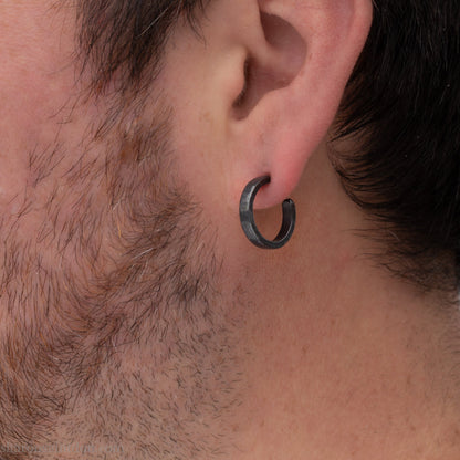 Handmade 925 sterling silver hoop earrings for men or women. 16mm x 3mm, round, oxidized black earrings with hammered texture, made by Sharon SaintDon in North America.