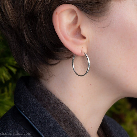 Handmade solid 925 sterling silver hoop earrings. 30mm diameter, 2mm wide, 1.5 thick. Silver posts and backs. Hammered by Sharon SaintDon in North America.