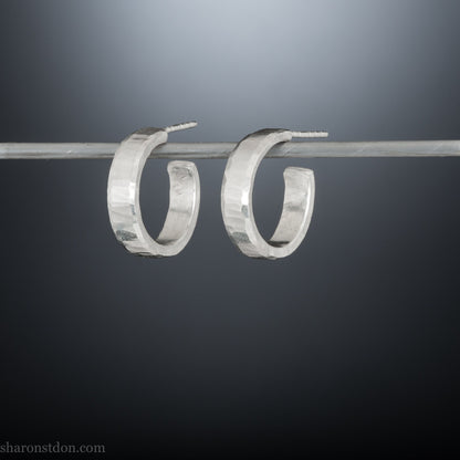 18mm x 4mm small sterling silver hoop earrings for for men or women, unisex. Handmade in North America by Sharon SaintDon. Hammered texture, solid silver with silver posts and backs.