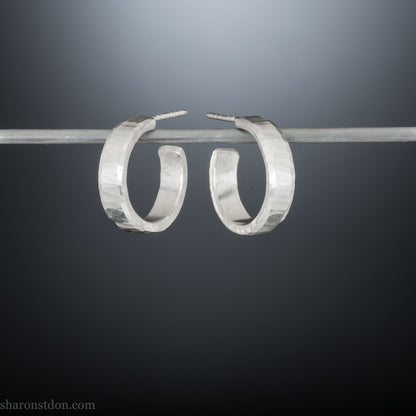 Small sterling silver hoop earrings, Handmade in North America by Sharon SaintDon. 18 x 4 x 1.5mm thick. Solid hammered silver with a matte, brushed finish, silver posts and backs.