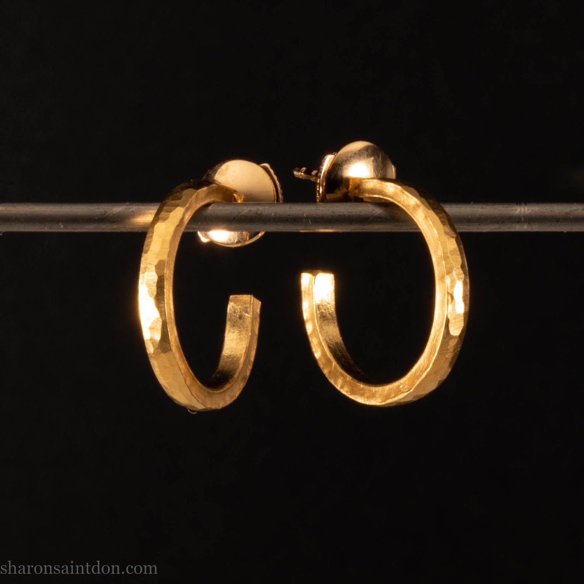 Solid yellow gold hoop earrings handmade in North America by Sharon SaintDon. Hammered solid 18k yellow gold, 18mm diameter round. Matte brushed finish and solid 18k gold posts and locking backs.