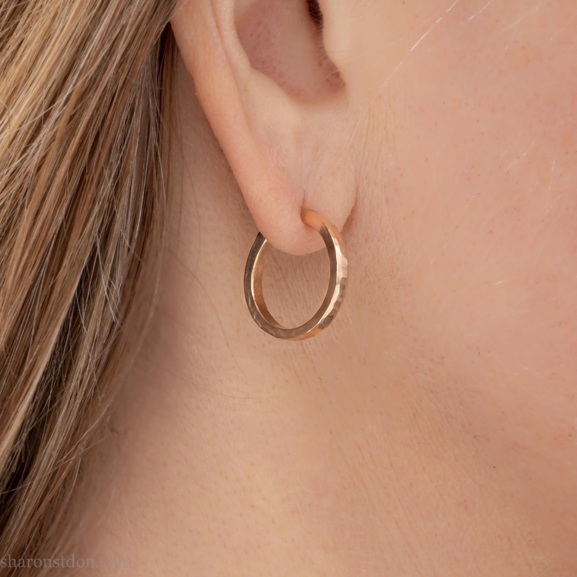 Solid yellow gold hoop earrings handmade in North America by Sharon SaintDon. Hammered solid 18k yellow gold, 18mm diameter round. Matte brushed finish and solid 18k gold posts and locking backs.