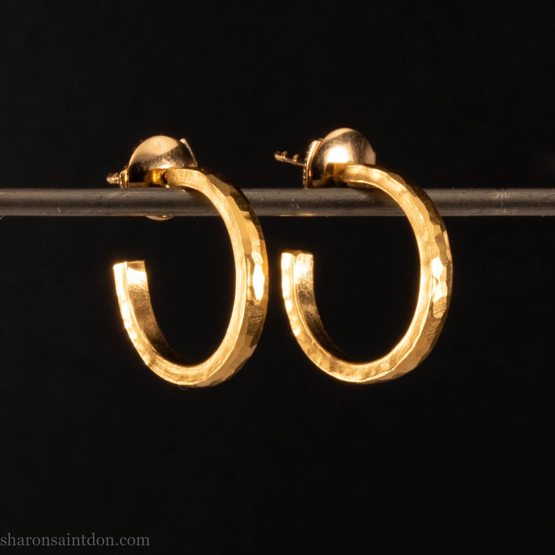 Solid yellow gold hoop earrings handmade in North America by Sharon SaintDon. Hammered solid 18k yellow gold, 18mm diameter round. Matte brushed finish and solid 18k gold posts and locking backs.
