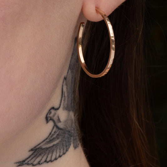 30mm diameter by 1.5mm thick handmade solid 14k yellow gold hoop earrings. Handmade by Sharon SaintDon in North America. Hammered from solid gold with a matte finish and locking backs.