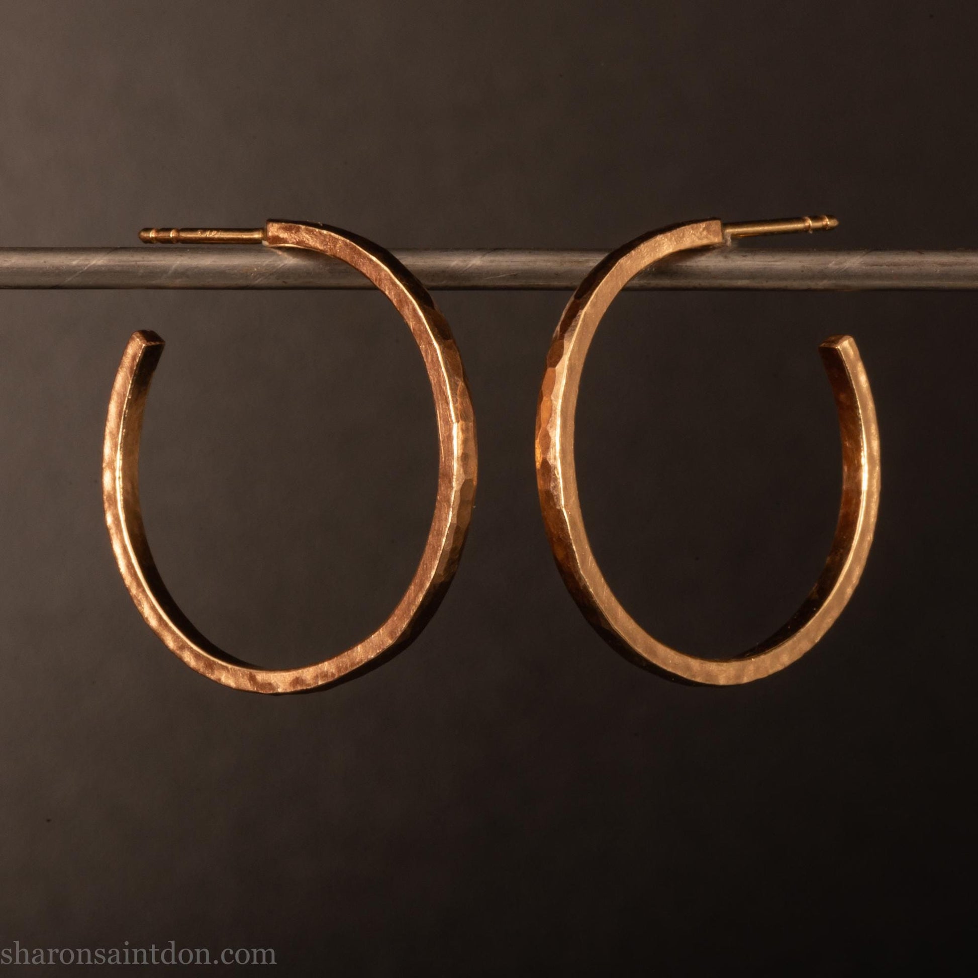 25mm diameter by 1.5mm thick  solid 14k yellow gold hoop earrings. Solid 14k gold posts and backs. Handmade by Sharon SaintDon in North America. Hammered from solid gold with a matte finish.