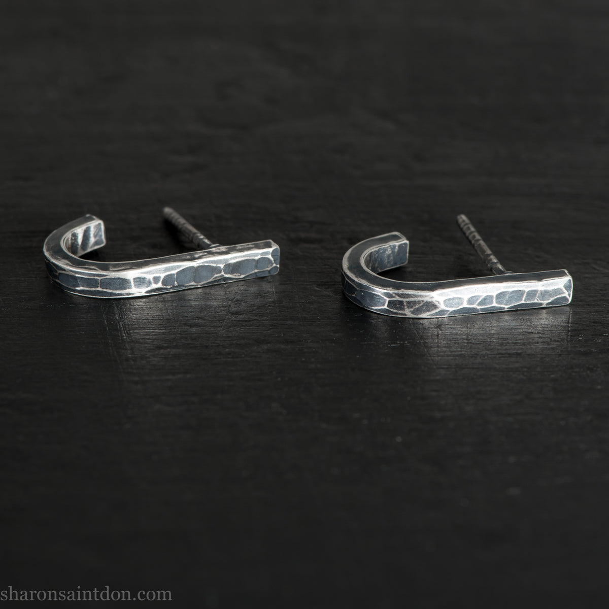 Hand hammered oxidized sterling silver J-wrap hoop earring, dark antique patina.