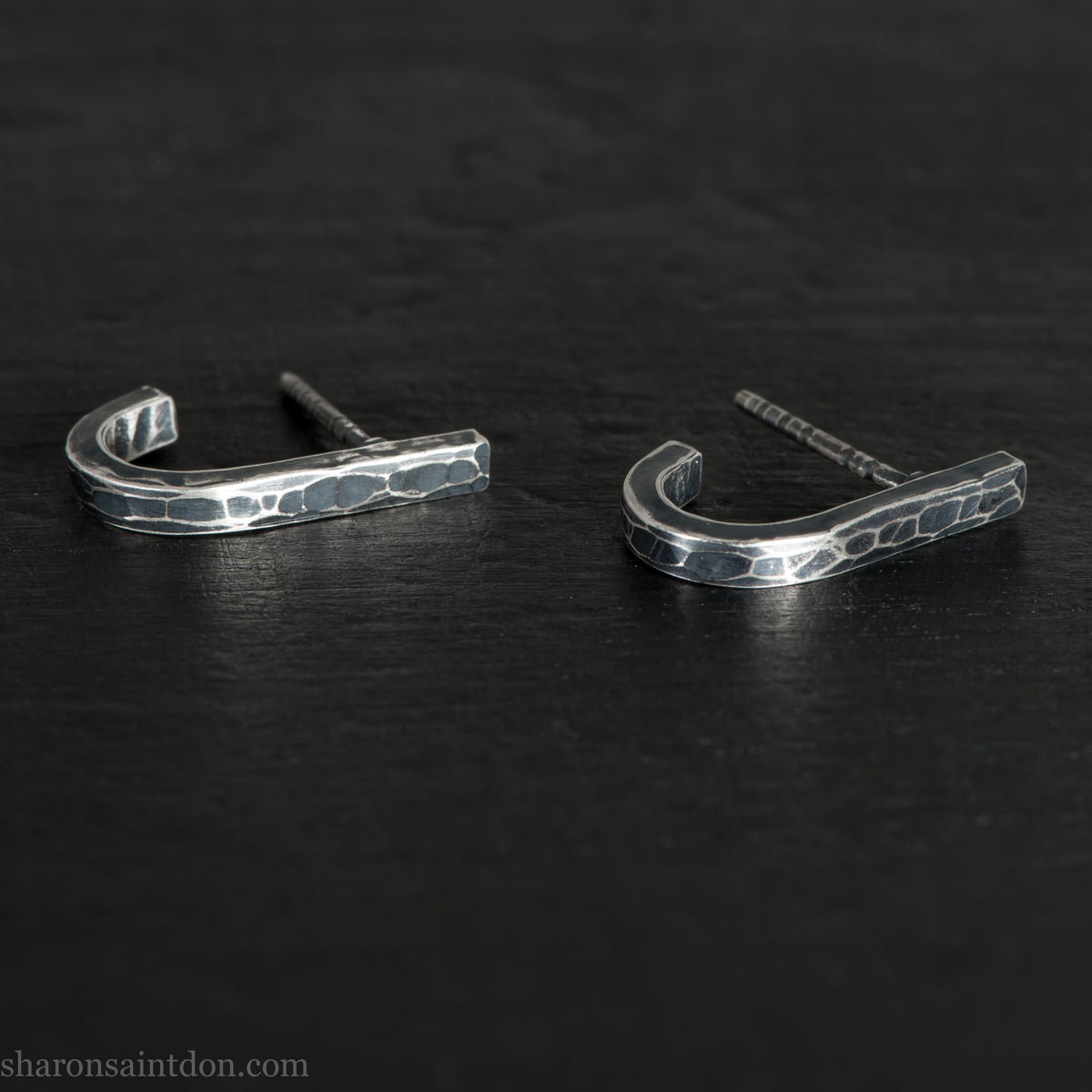 Hand hammered oxidized sterling silver J-wrap hoop earring, dark antique patina.