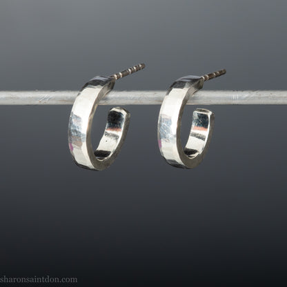 Close-up view of hand-hammered 925 sterling silver hoop earring, 14mm diameter, 3mm wide, 1.5mm thick, brushed matte satin finish.