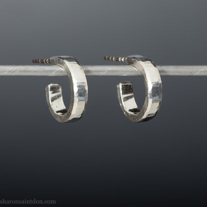 Close-up view of hand-hammered 925 sterling silver hoop earring, 14mm diameter, 3mm wide, 1.5mm thick, brushed matte satin finish.