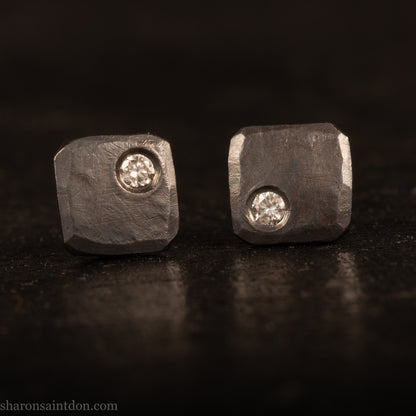 Handcrafted 7mm square sterling silver stud earrings, oxidized black with a 2mm round moissanite gemstone set in the corner.