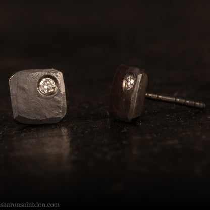 Handcrafted 7mm square sterling silver stud earrings, oxidized black with a 2mm round moissanite gemstone set in the corner.